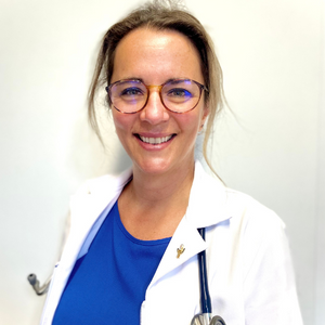 Eve Routhier smiling in a medical jacket with a stethoscope in her left pocket